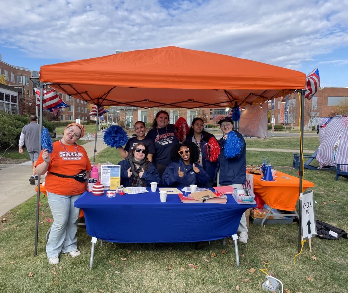 Students beneath a bright orange canopy outside of the Enterprise Center during the Party at the Polls in 2024