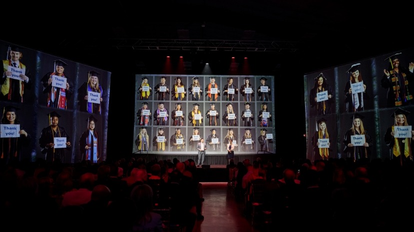 Dean Raminder Luther and alumnus Julio Hernandez in front of screen of scholarship recipients at the Meet the Moment campaign launch on May 6, 2023.