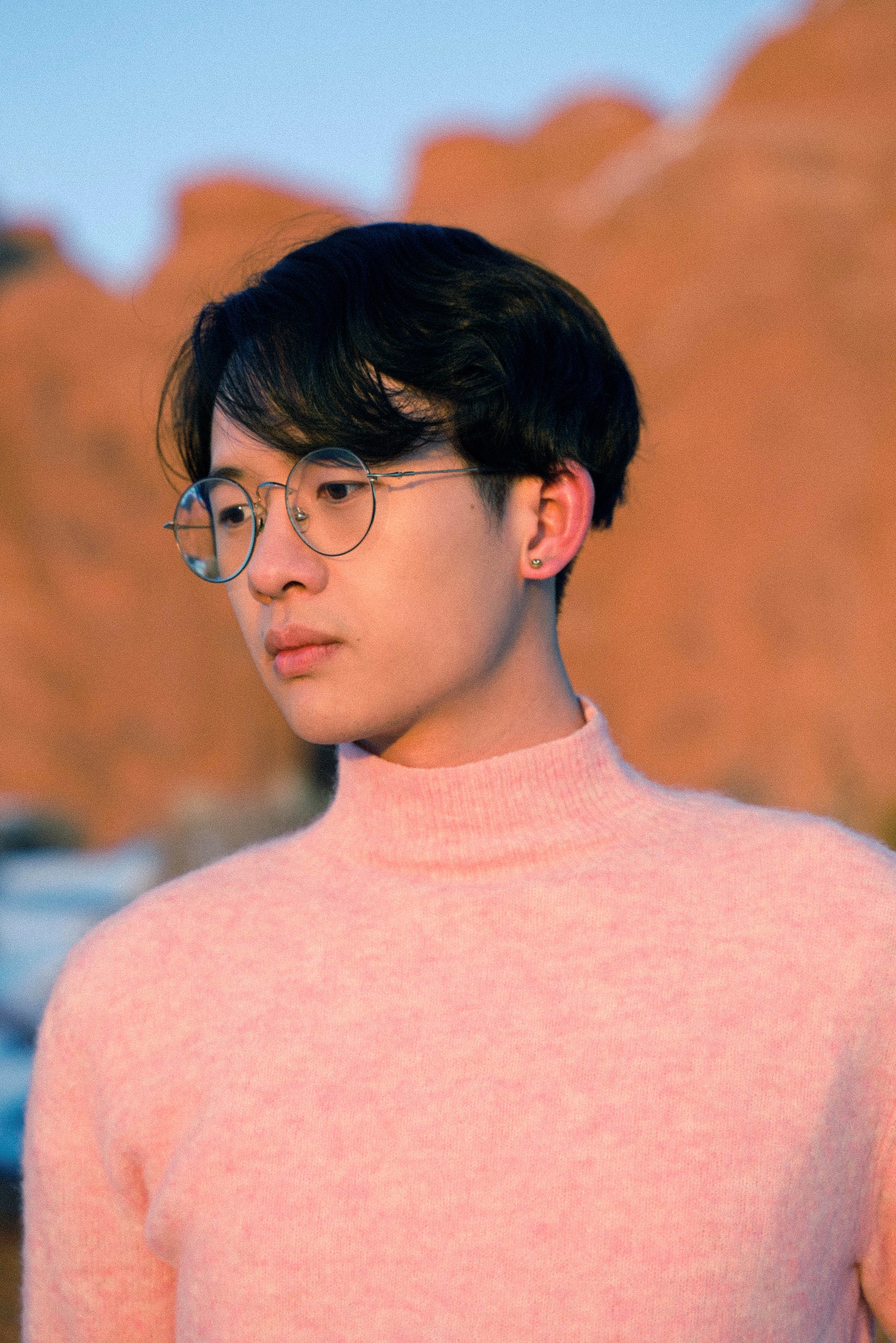 Shangyang Fang in a pink turtleneck in front of a tree