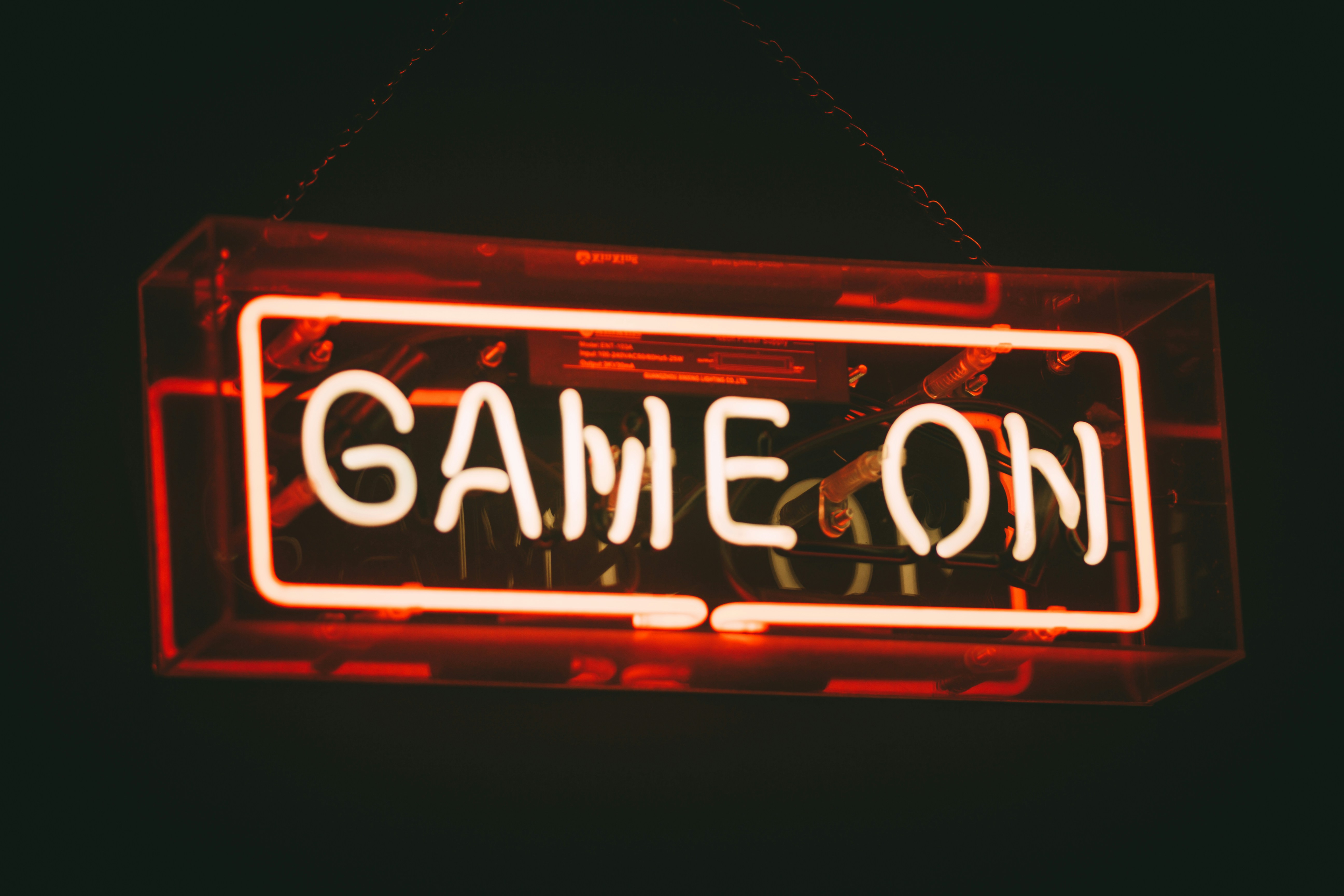 "Game on"  lit up in a red neon, rectangular sign.