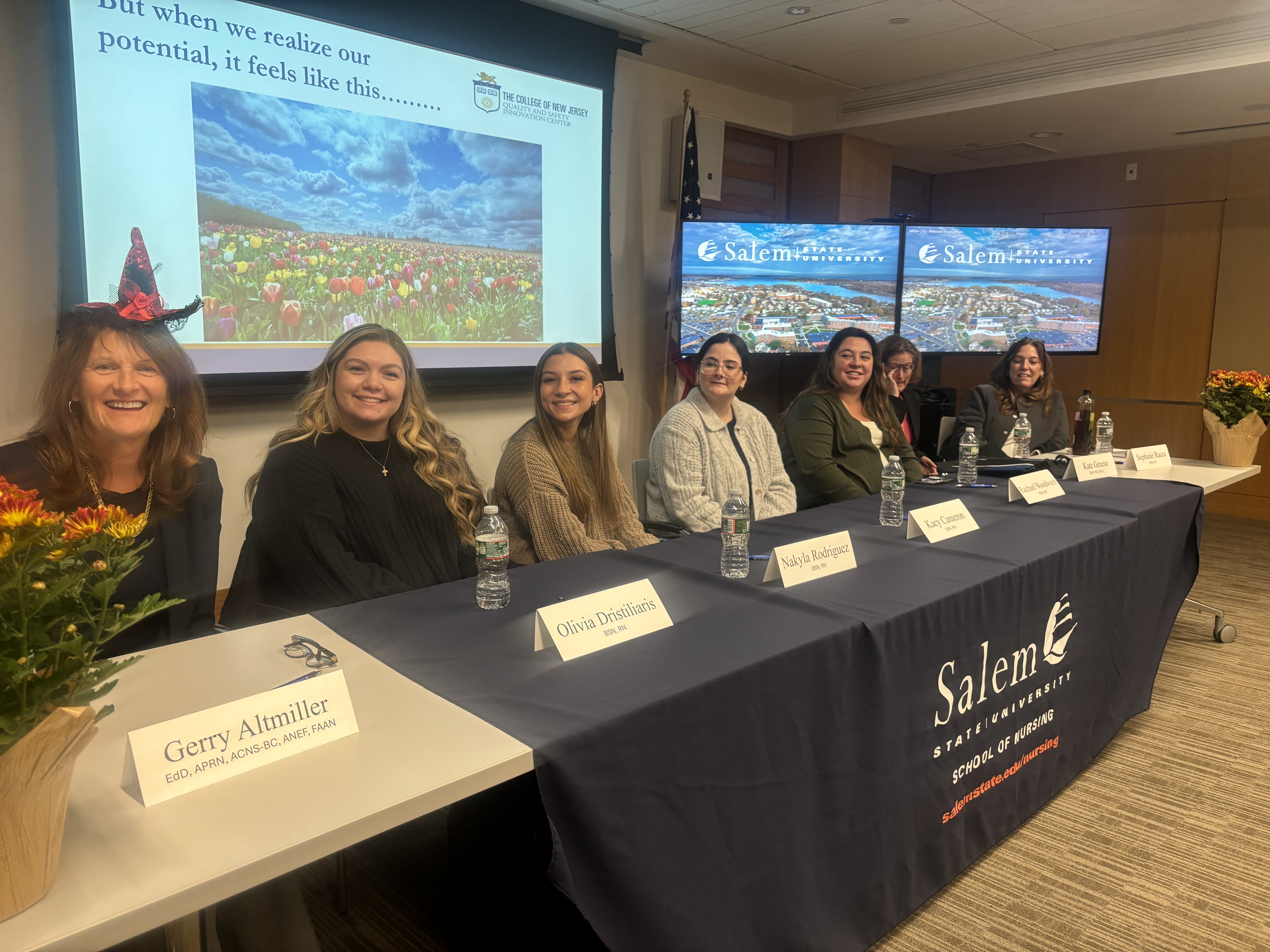 Salem State nursing students sit behind a table