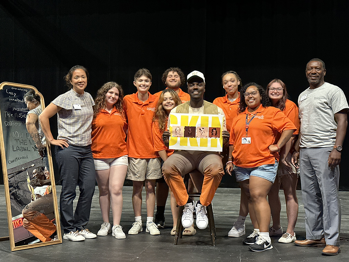 Orientation and student life leaders with an orientation speaker on stage