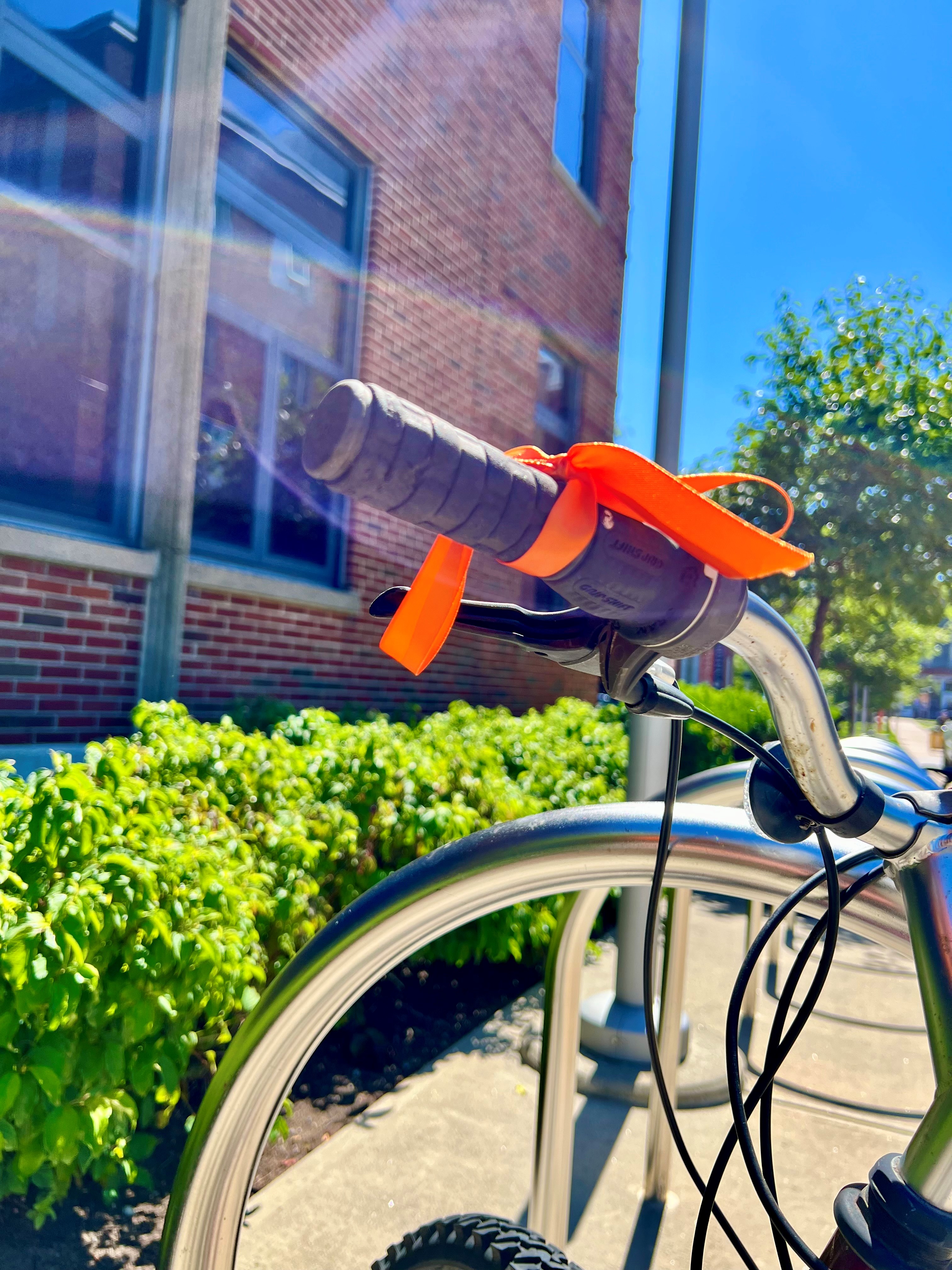 Bike with an orange ribbon tied to the handlebar.