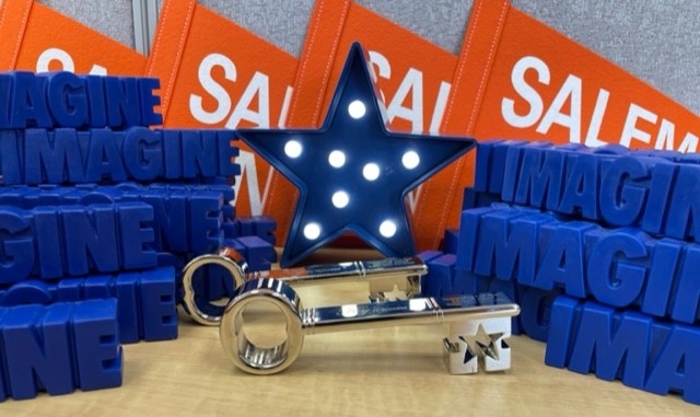 Image of silver keys with blue light up star and Salem State pennants behind them, with 3-D words "imagine" piled up on either side