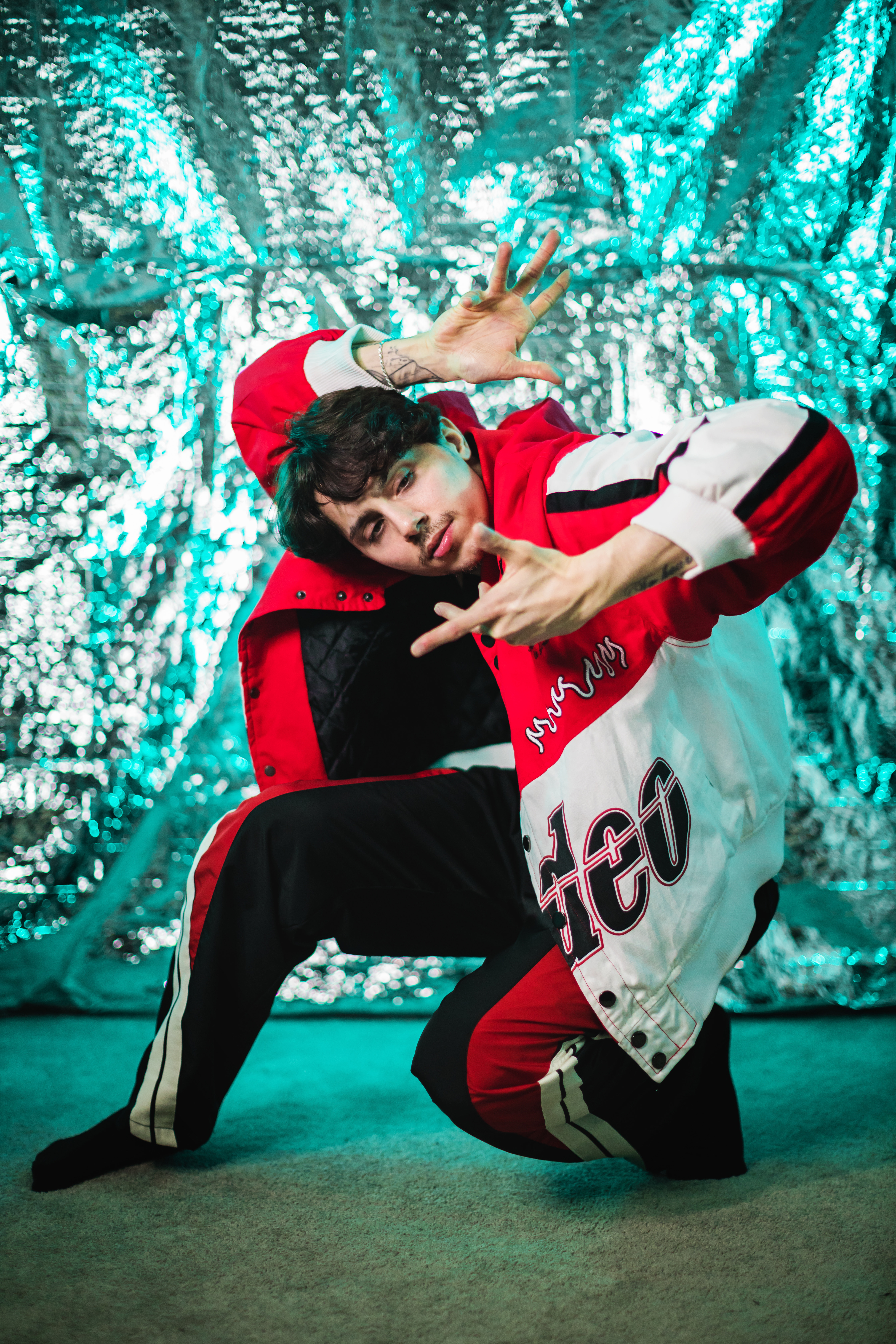 Person on one knee in red and white jacket