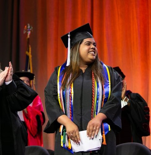 Anngerline Burgos standing on the stage at commencement