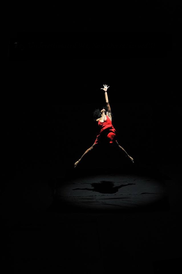 Dancer dressed in red leaping in the air