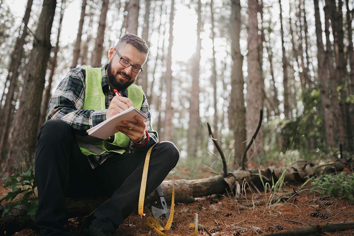 A man in the woods recording data