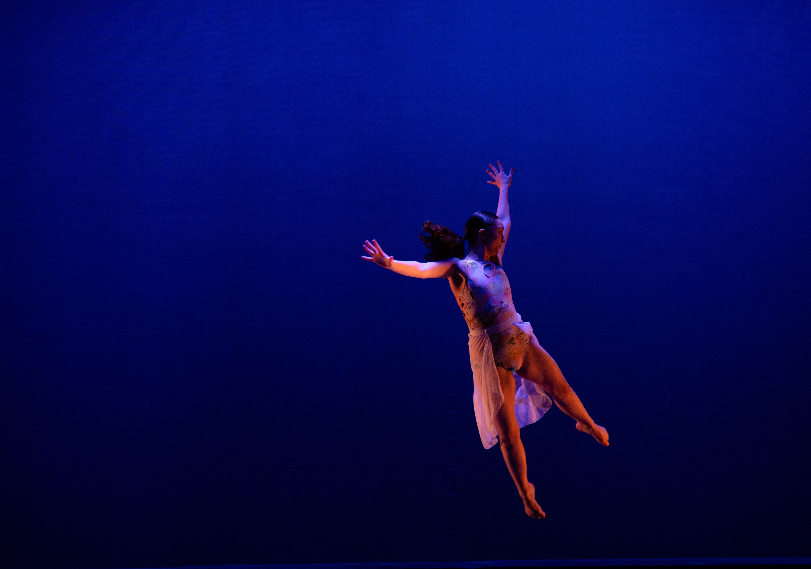 Woman dressed in white jumping in the air