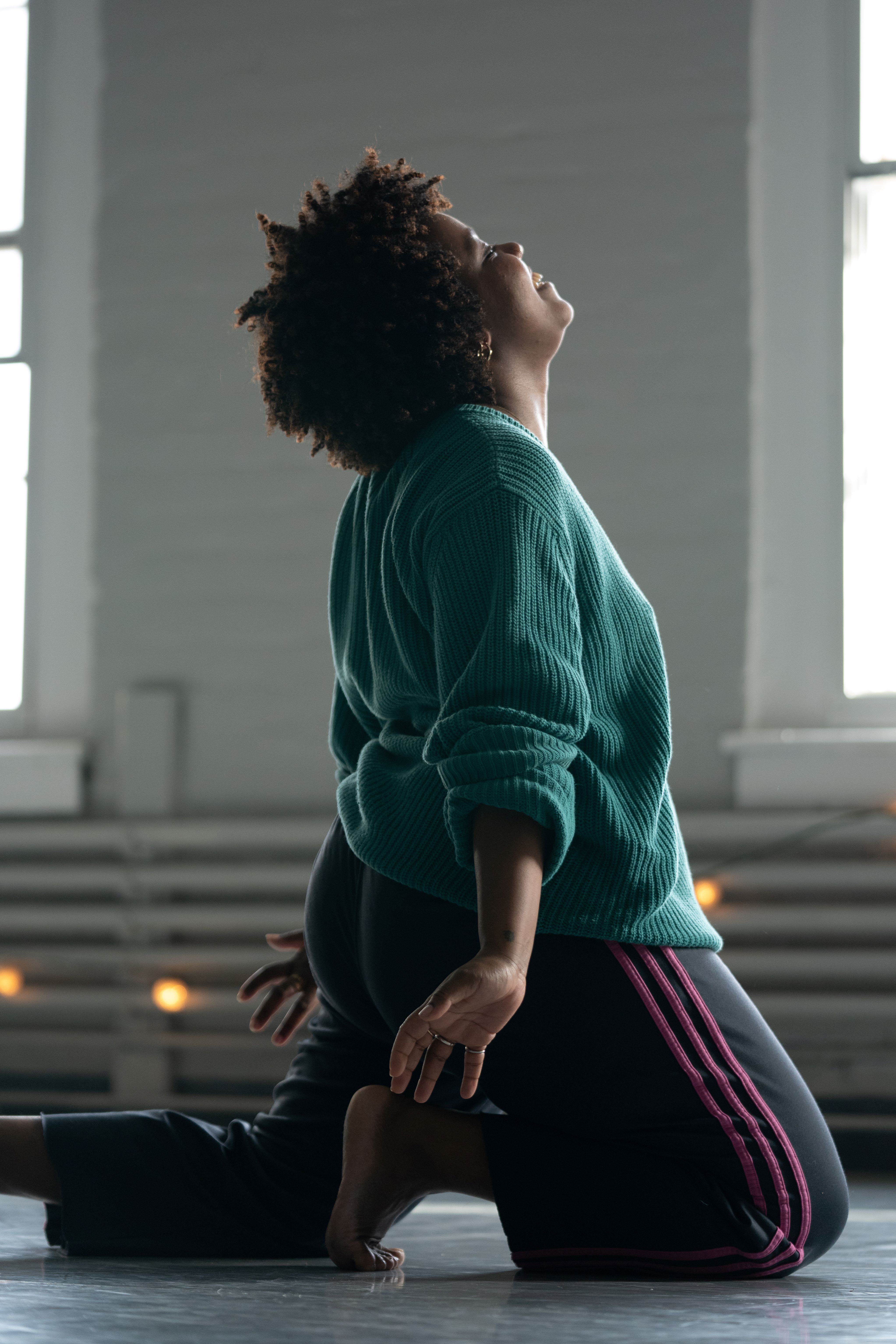 Person kneeling with arms extended