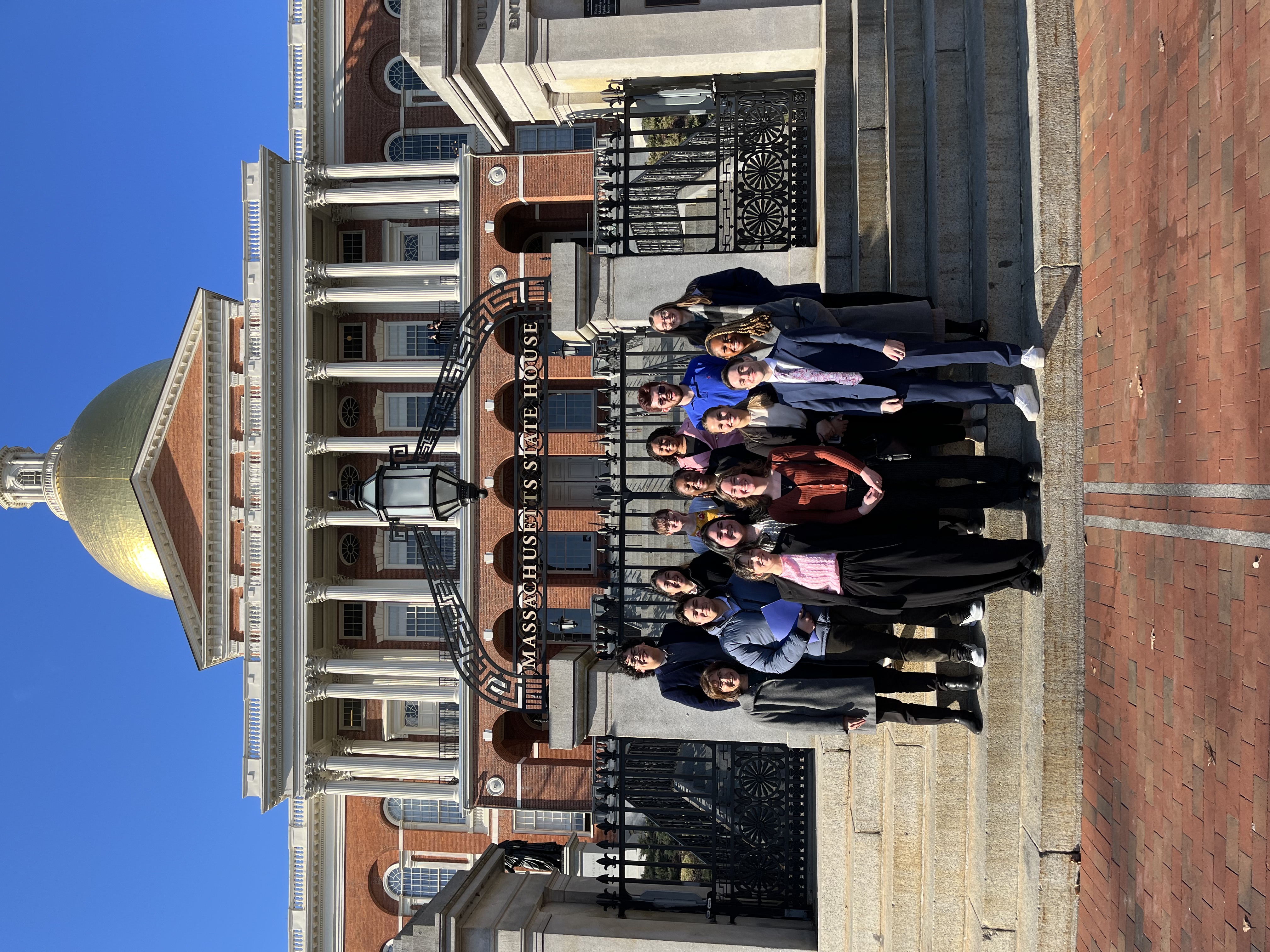 Alternative Spring Break Trip 2024 participants in front of the Massachusetts State House.