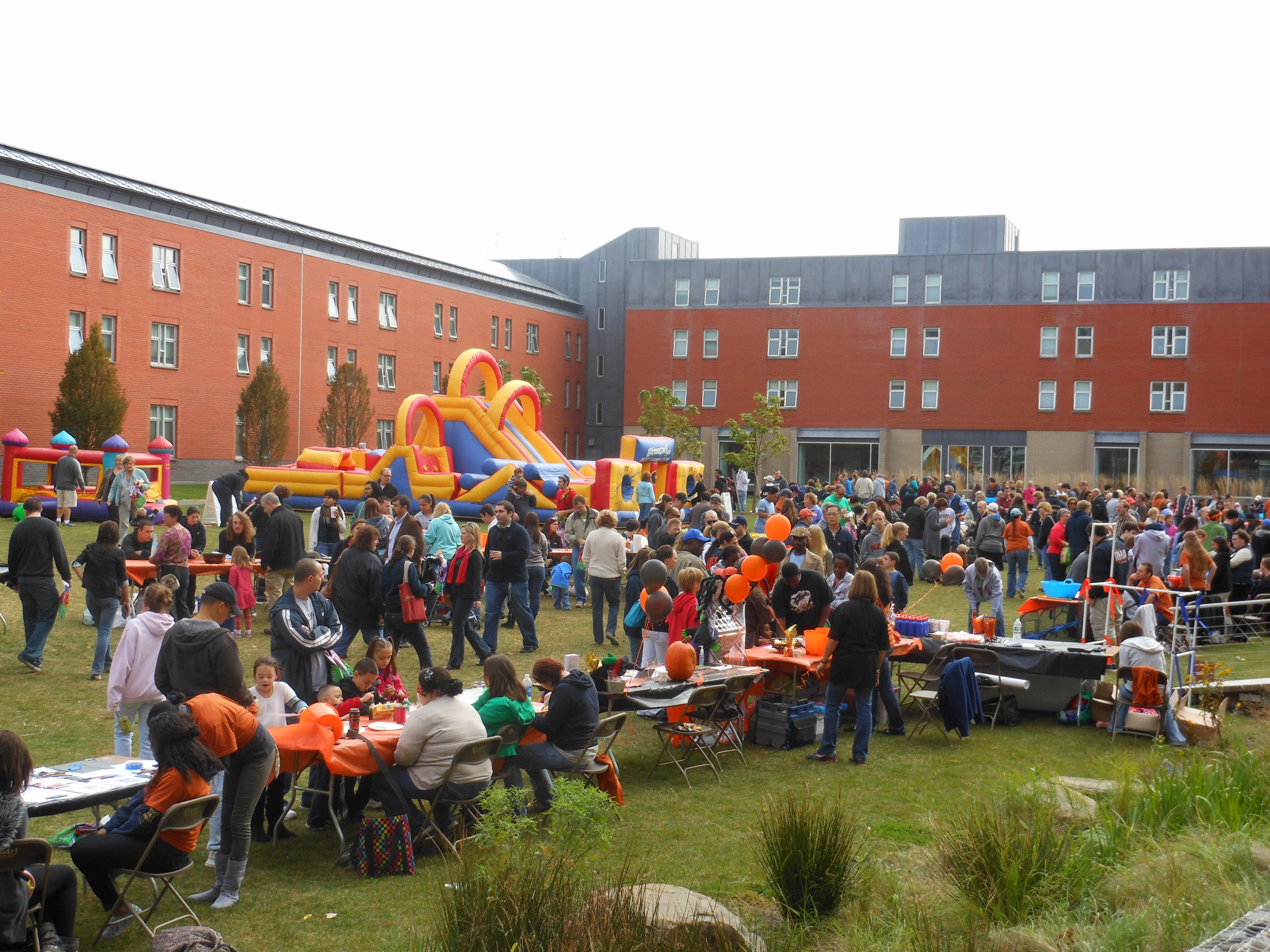 Students and families celebrating at outdoor carnival in front of Atlantic Hall