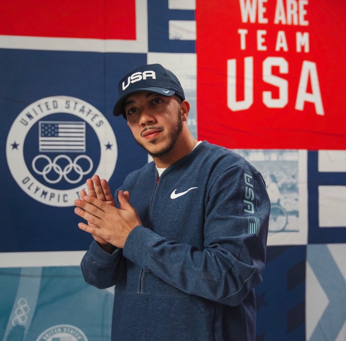 Alex Diaz in Blue Olympic Hat and Jacket