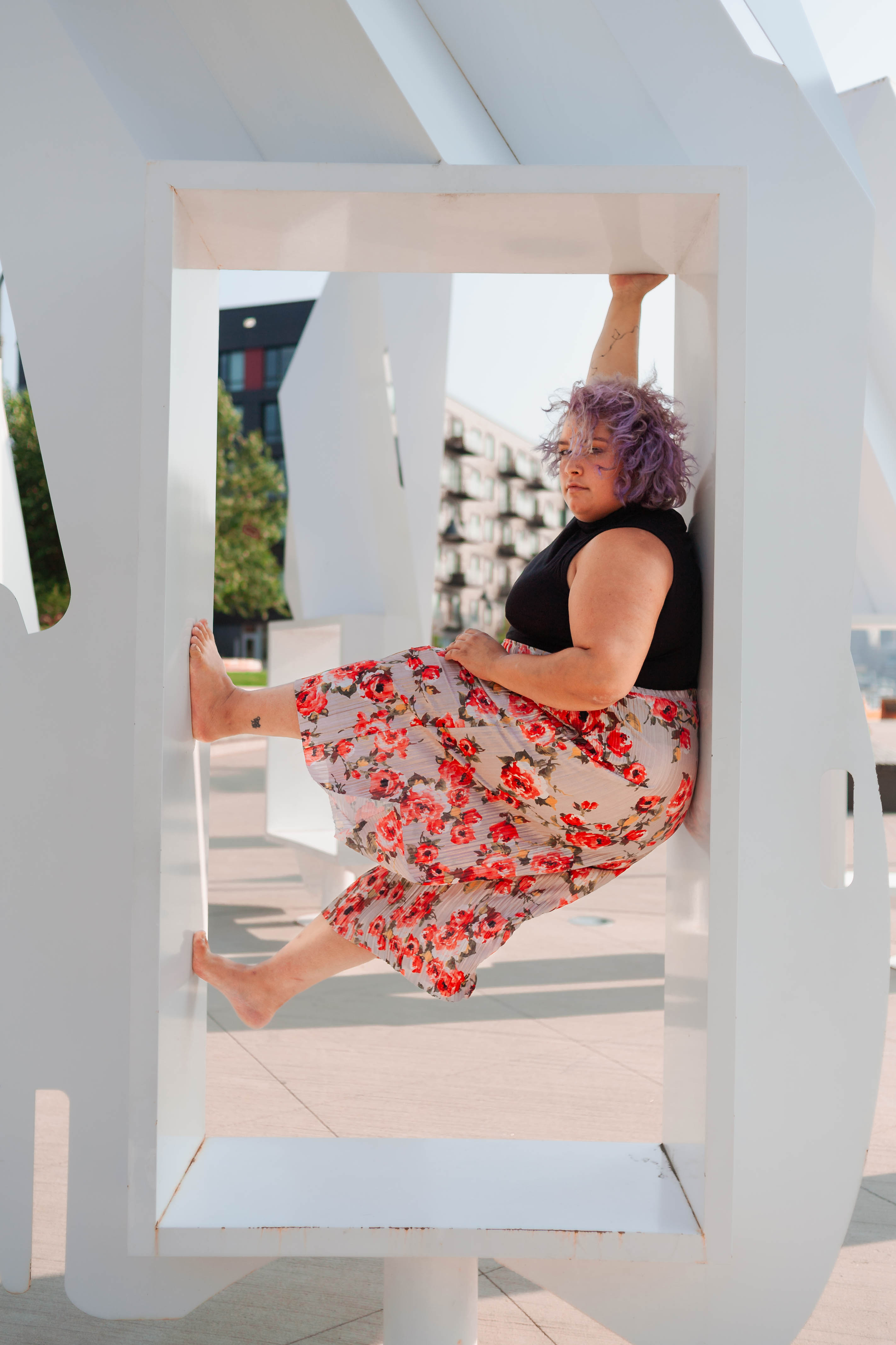 Angelina Benitez in  a window frame wearing floral skirt and black top