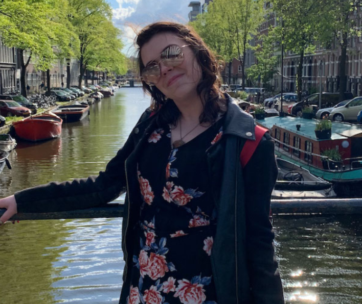 Martine Geary-Souza stands in front of a canal wearing sunglasses.