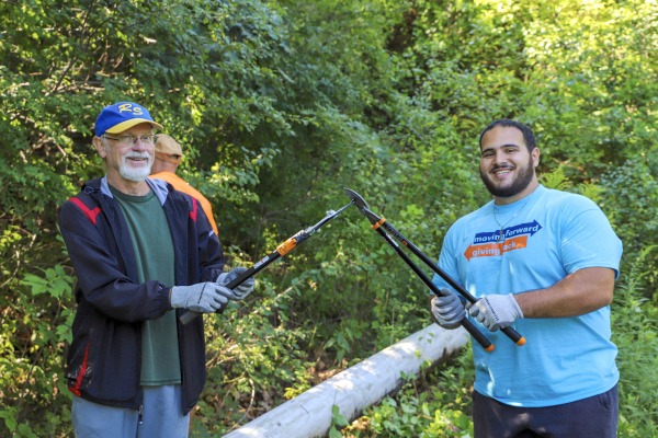 Salem State student and community partner outside doing yard work