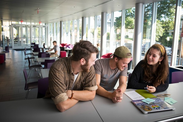 three students study together at a table in the Sophia Gordon Center. 