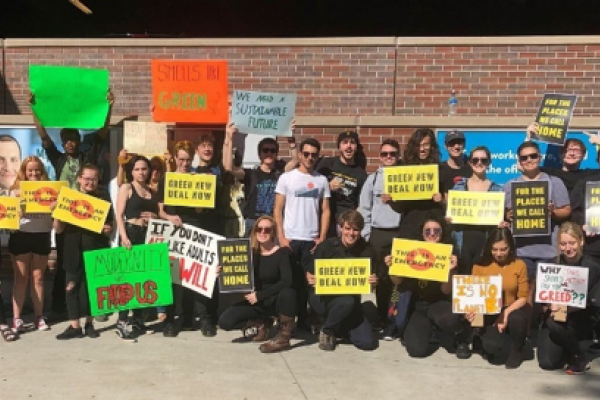 Sunrise Movement group holding signs at Salem State