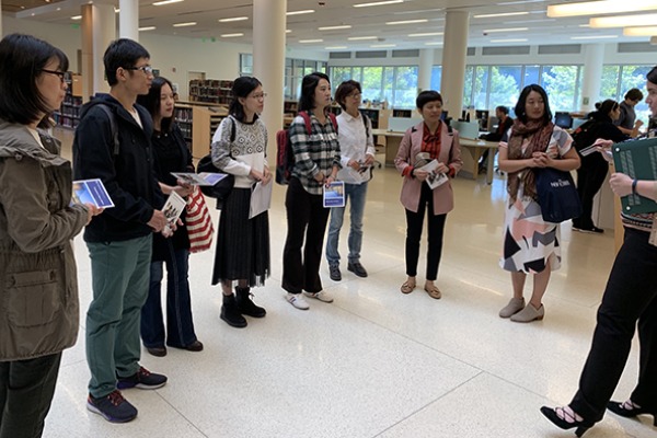 A group  of visiting scholars in the Berry Library atrium