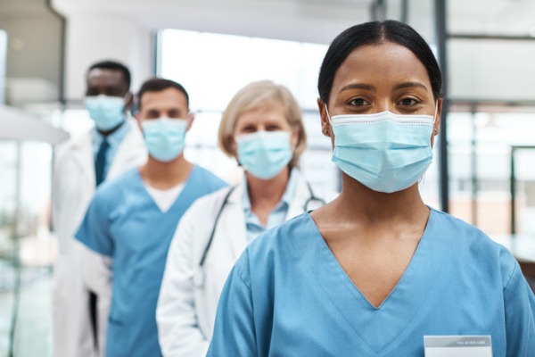 Portrait of a group of medical practitioners wearing face masks while standing together in a hospital