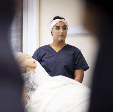 Student in nursing lab with simulation dummy