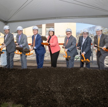 Salem State community members holding shovels as part of a ceremonial groundbreaking